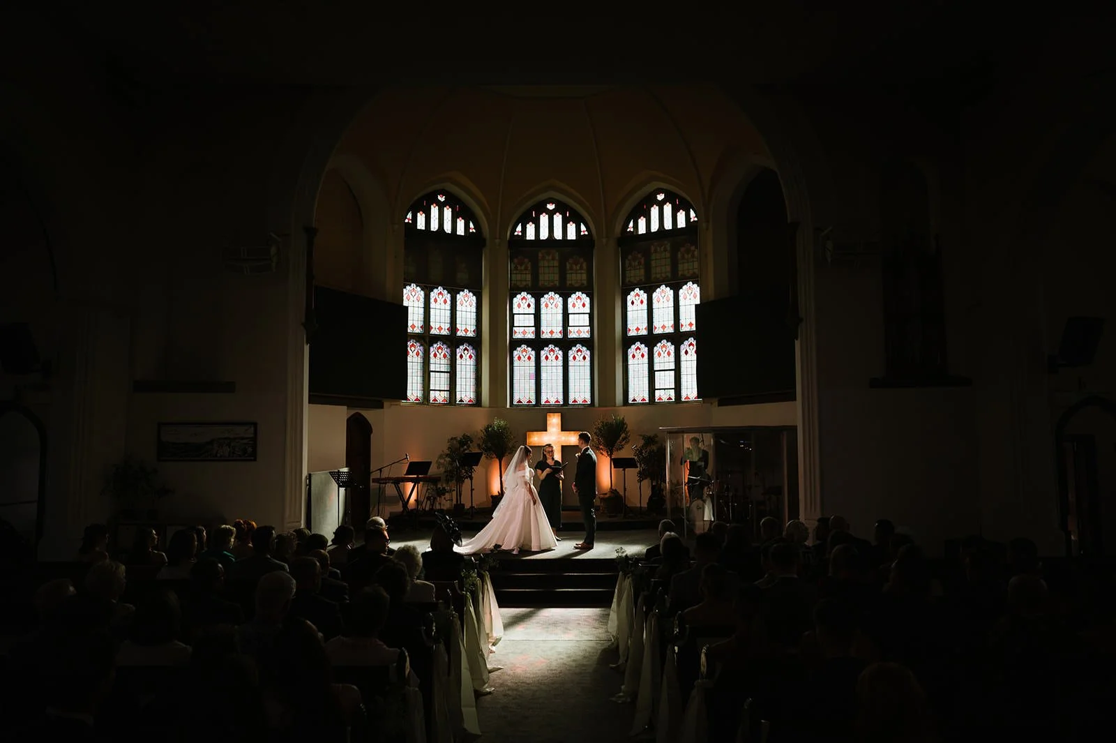 Wedding ceremony with sunlight streaming through church windows