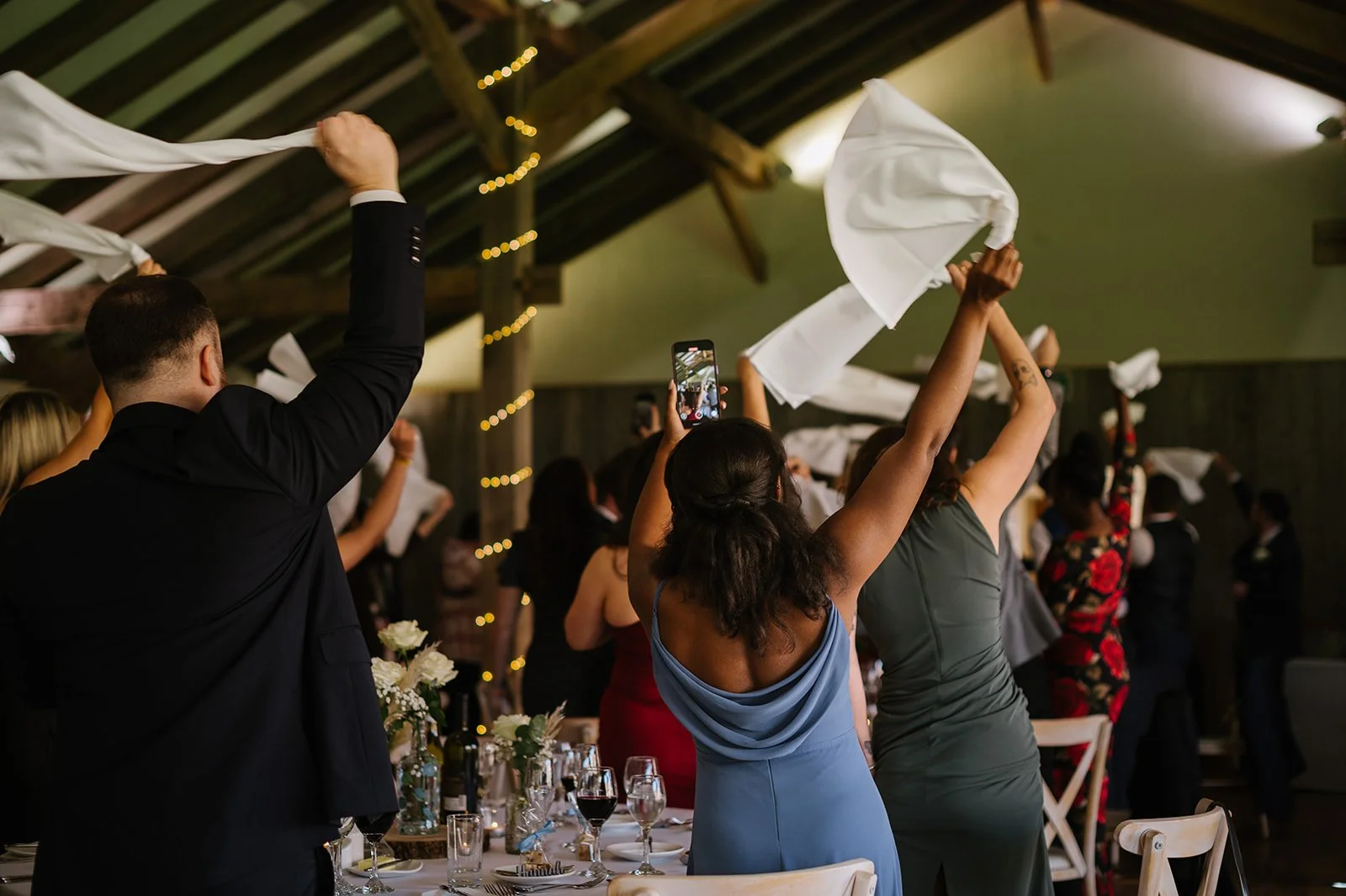 Wedding reception entrance with guests waving napkins