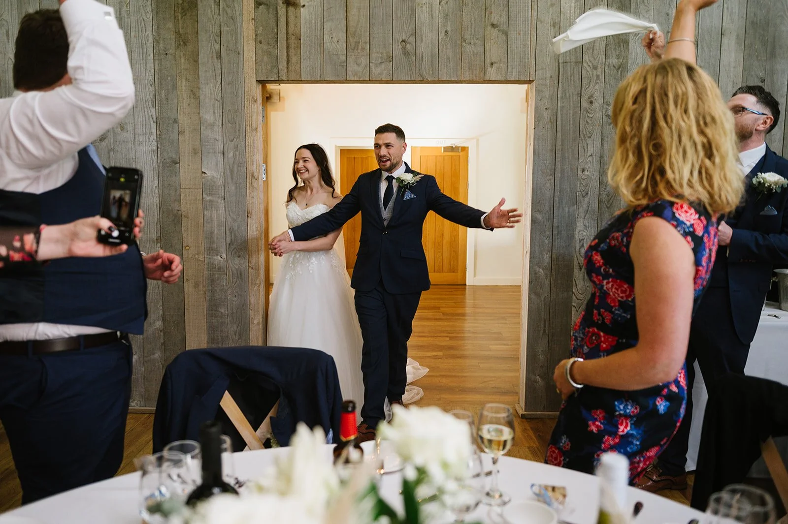 Wedding reception entrance with guests waving napkins