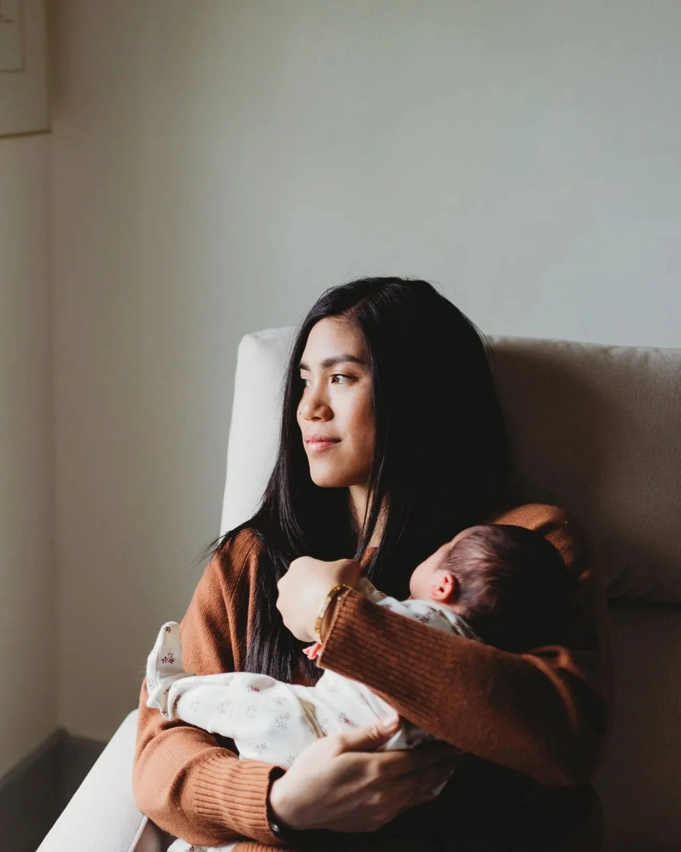 Seattle newborn photographer — lifestyle in-home newborn session in Capitol Hill, mother holding sleeping baby by window