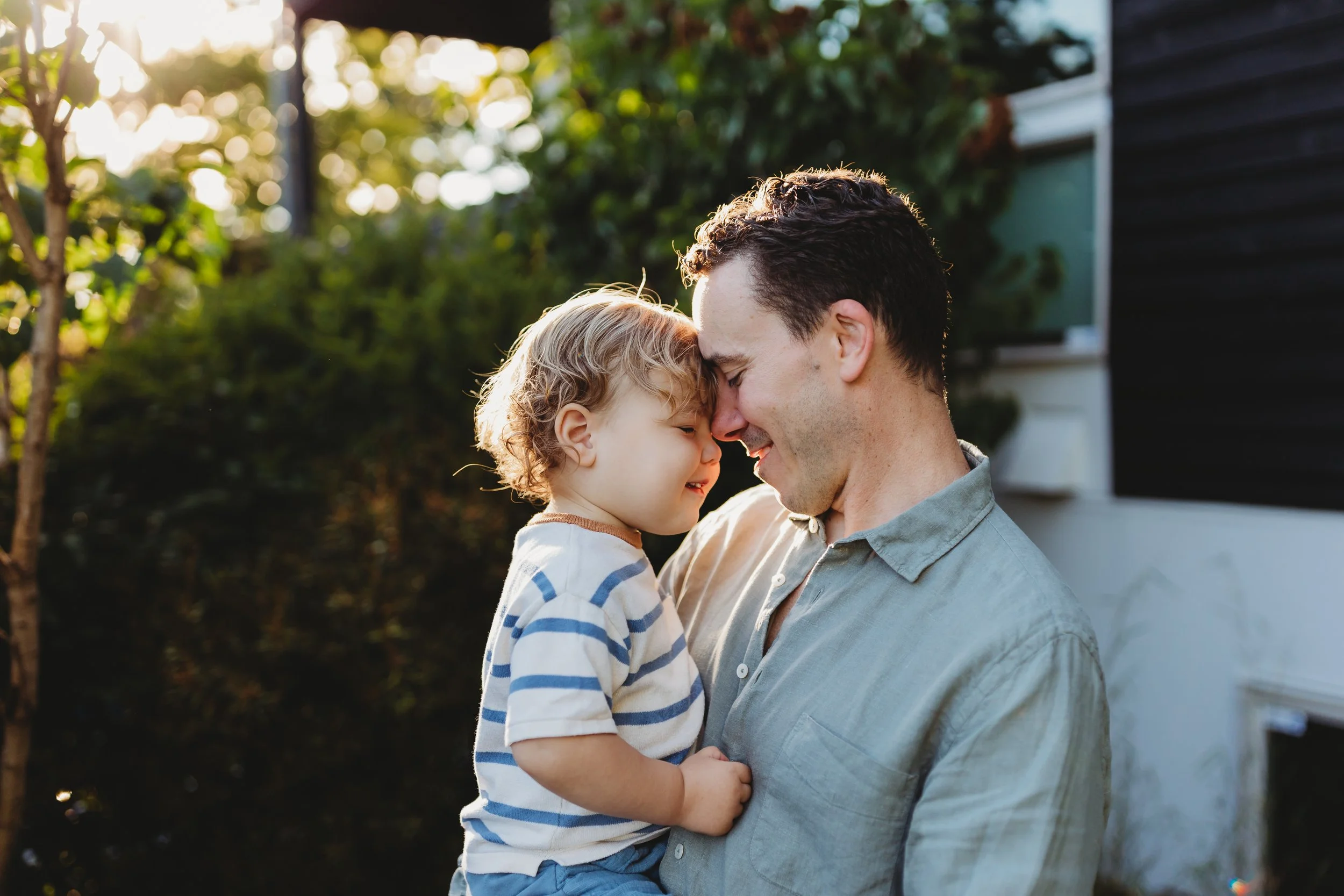 Father and toddler touching foreheads and smiling during a golden hour family session — Seattle lifestyle photographer
