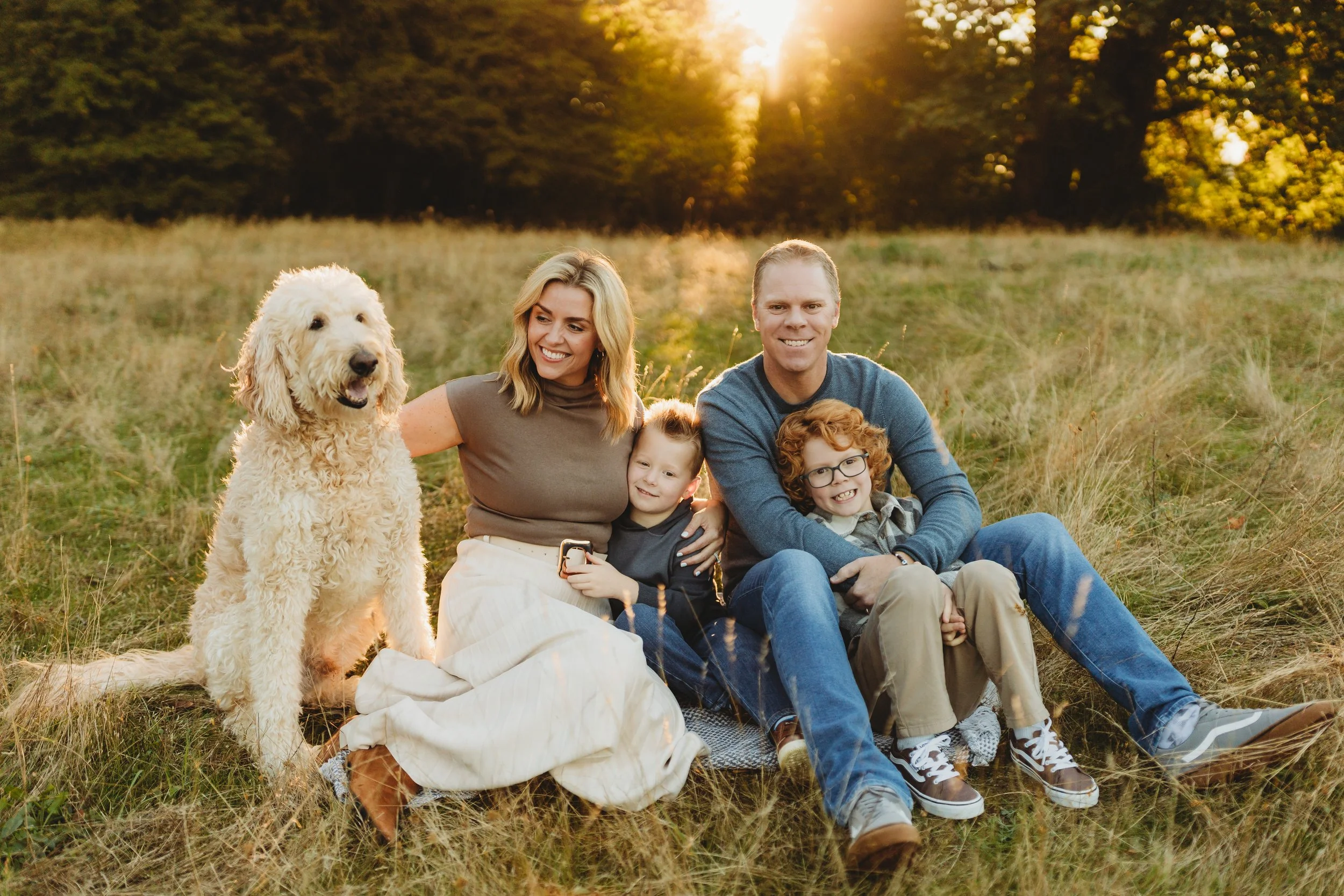 Family of four with their goldendoodle sitting together at golden hour, Seattle fall mini session