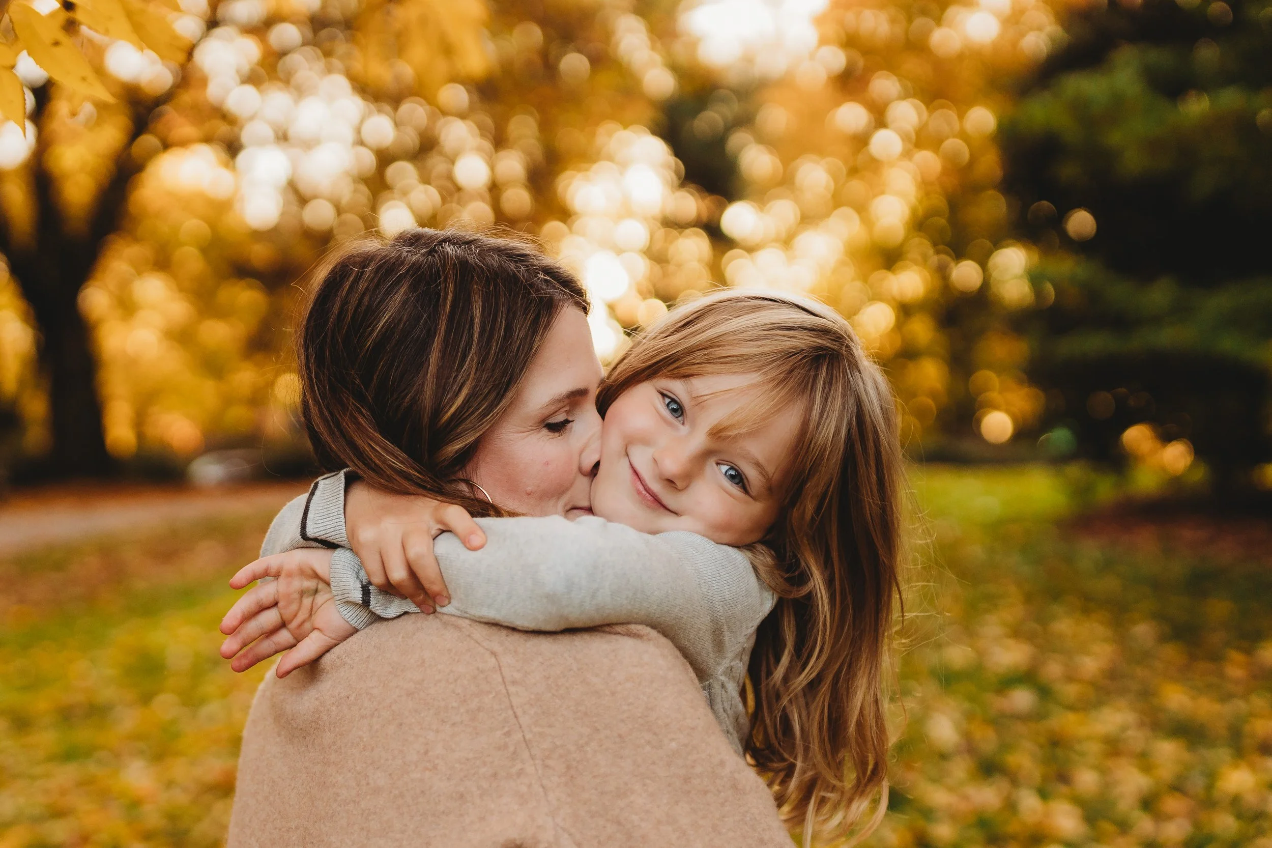 Mom hugging her daughter close, both smiling, Volunteer Park fall mini session, Seattle photographer