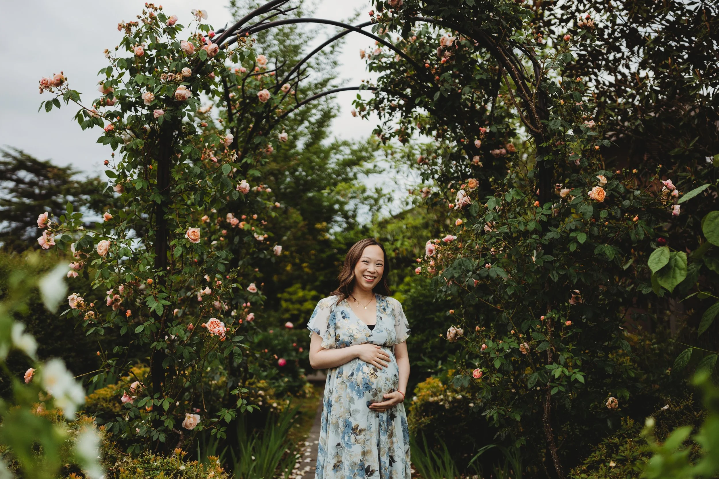 Pregnant woman during a maternity photo session at the Center for Urban Horticulture in Seattle, surrounded by lush greenery