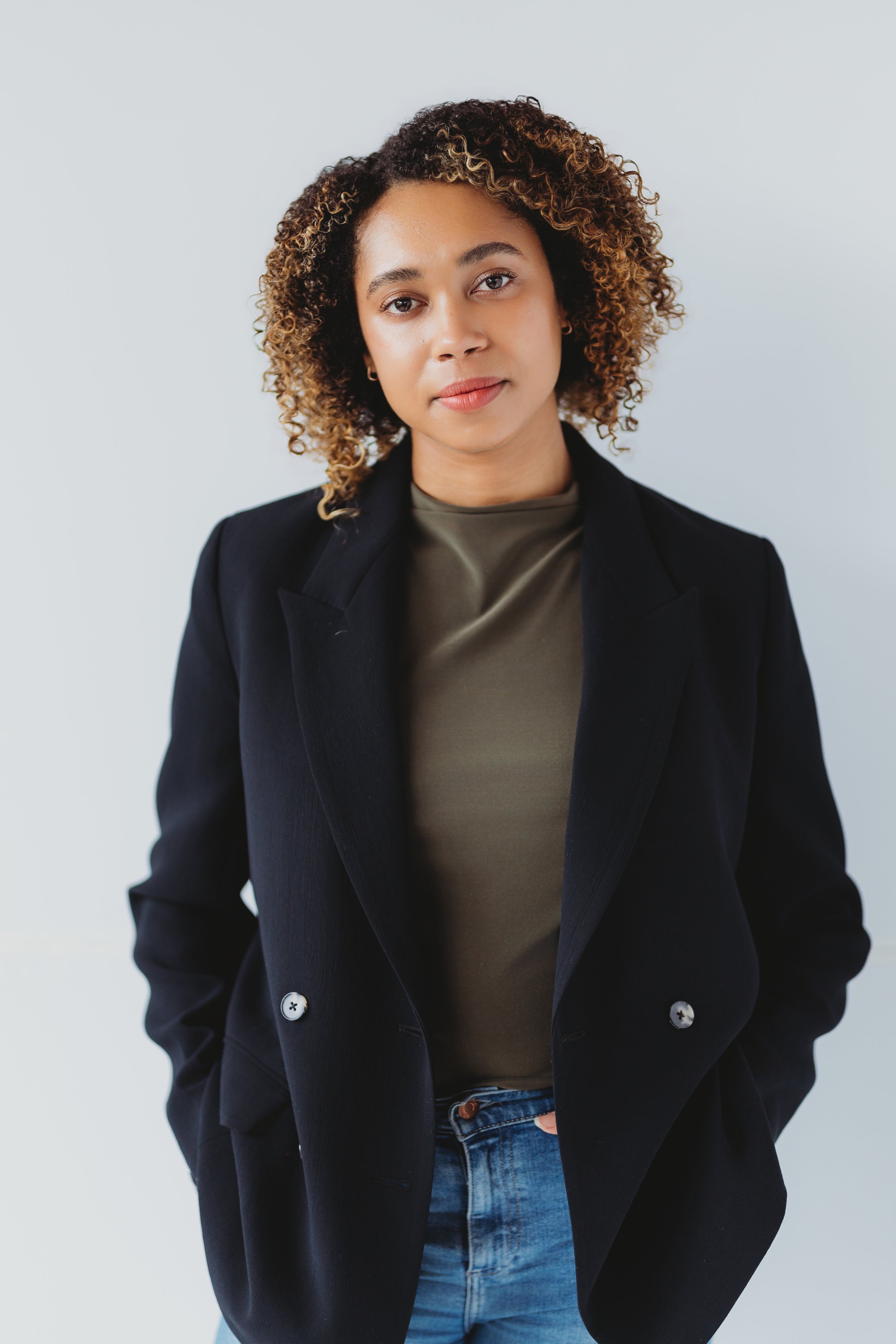 A professional studio headshot photographed in Seattle featuring relaxed hand placement with hands in pockets. This pose creates a confident, approachable look while helping clients feel comfortable and natural on camera.