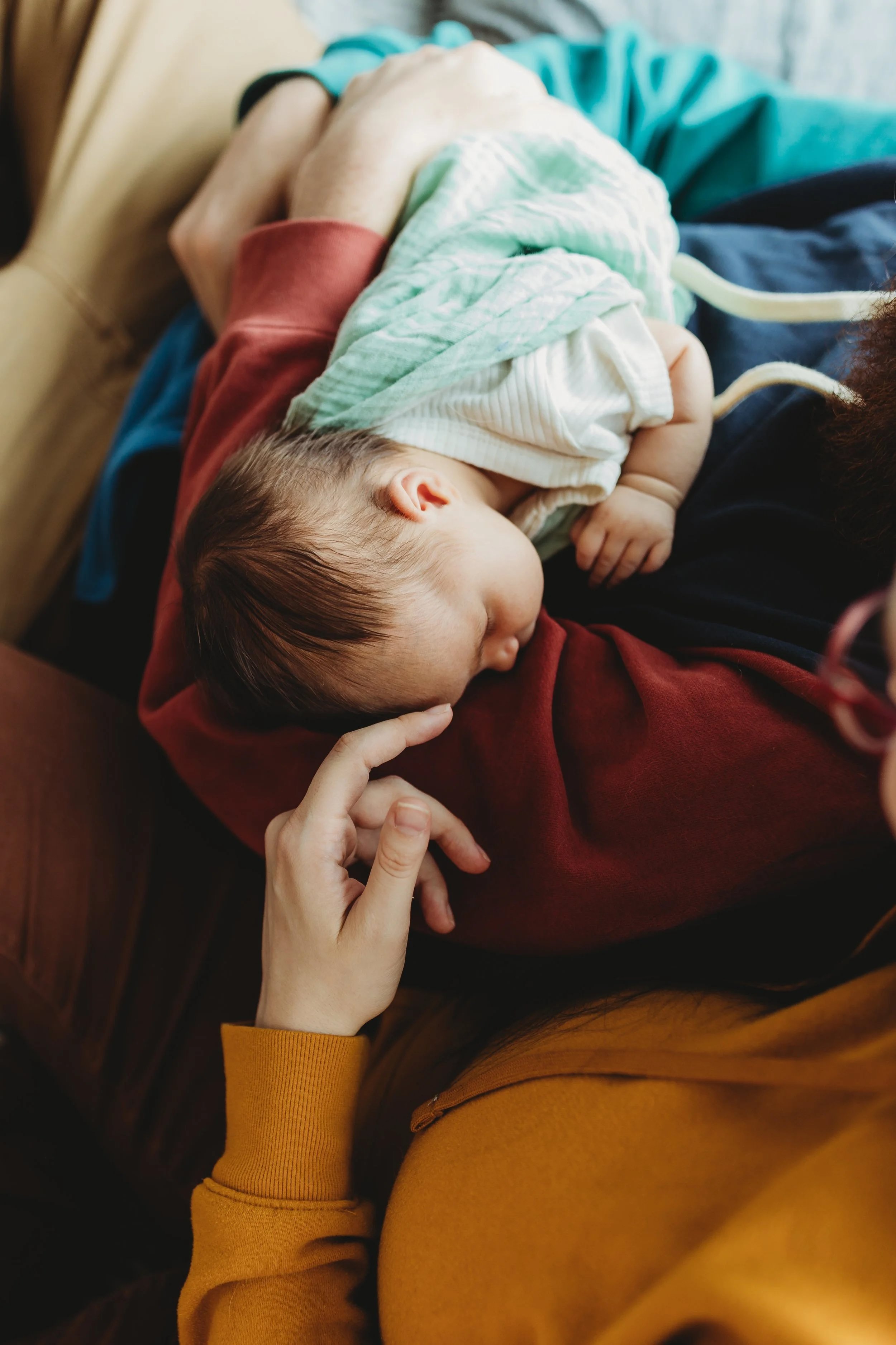 Newborn resting peacefully on a parent during a relaxed, baby-led in-home newborn photography session in Seattle.