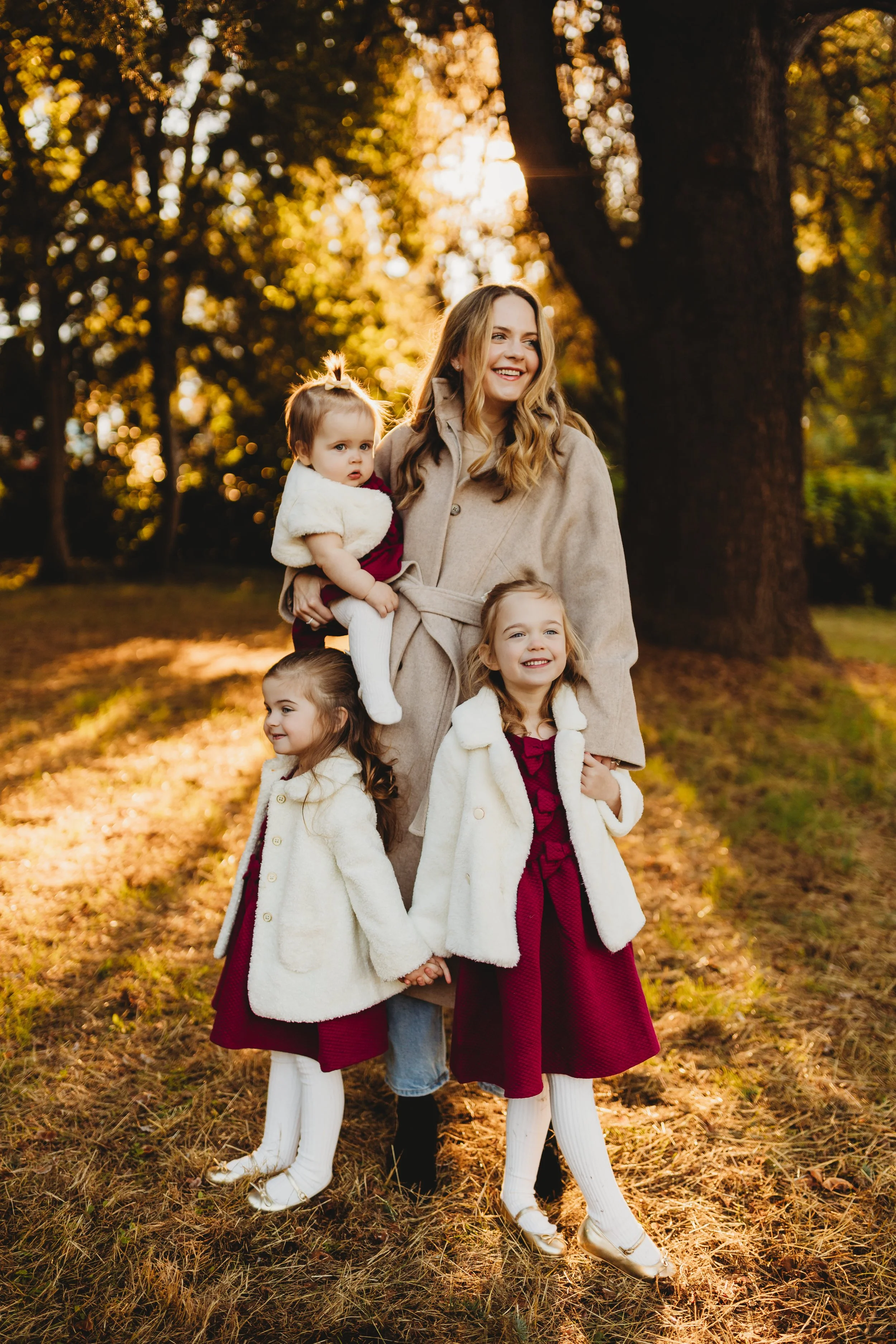 Mom laughing with three daughters in golden backlit light during fall family photos in Seattle