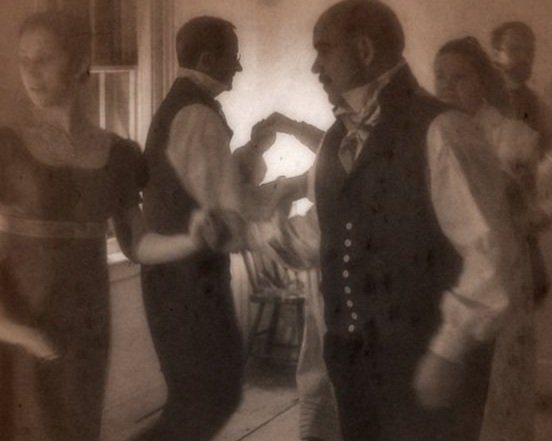 Vintage photo of colonial dressed people engaging in a choreographed dance.