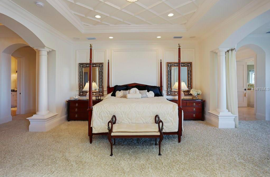 The master suite is spacious and overlooks sparkling waters, with his and hers bathrooms and high, custom ceilings.