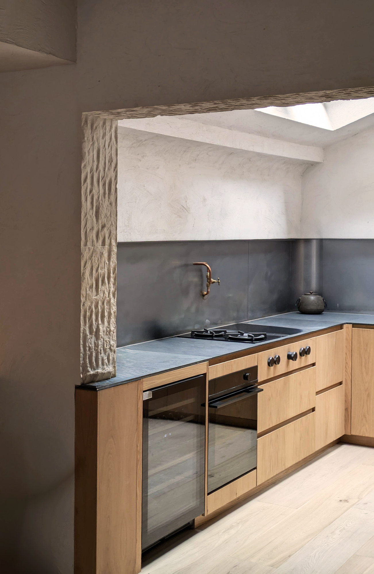 Renovation to a Conservation Area Mews House in Chelsea, with bespoke oak kitchen and skylight, with stone and lime render walls.