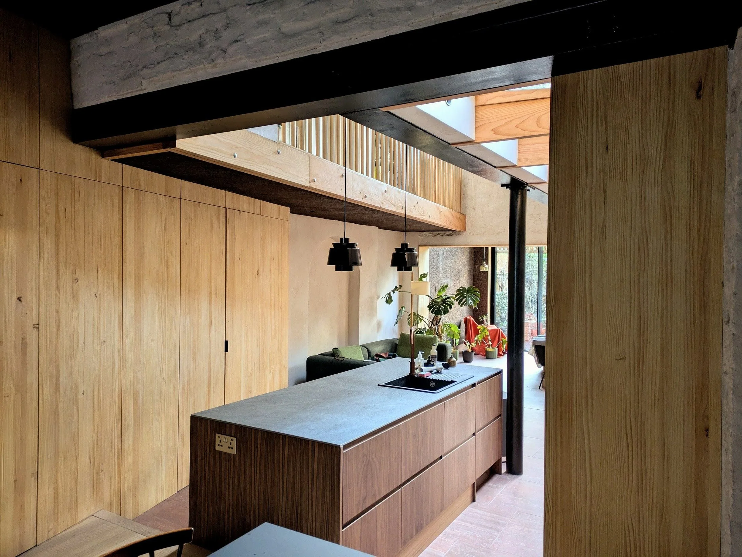 Solid Pine panel storage units and walls line the double-height kitchen and living room space (Image by Polysmiths)