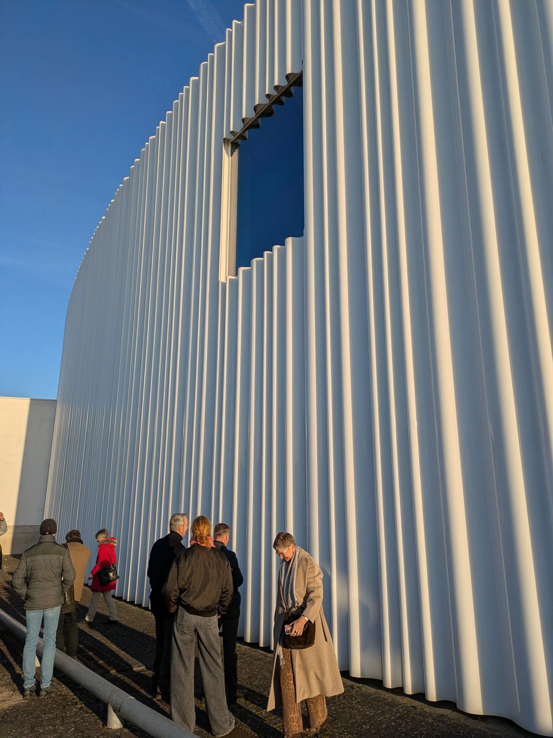 SANAA’s factory building with a beautiful curtain wrapping around it, with the whimsical cut out details around the window.