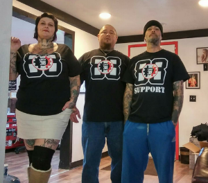 The co-owners and an employee rep their Northwest Hammerskins shirts in the shop.