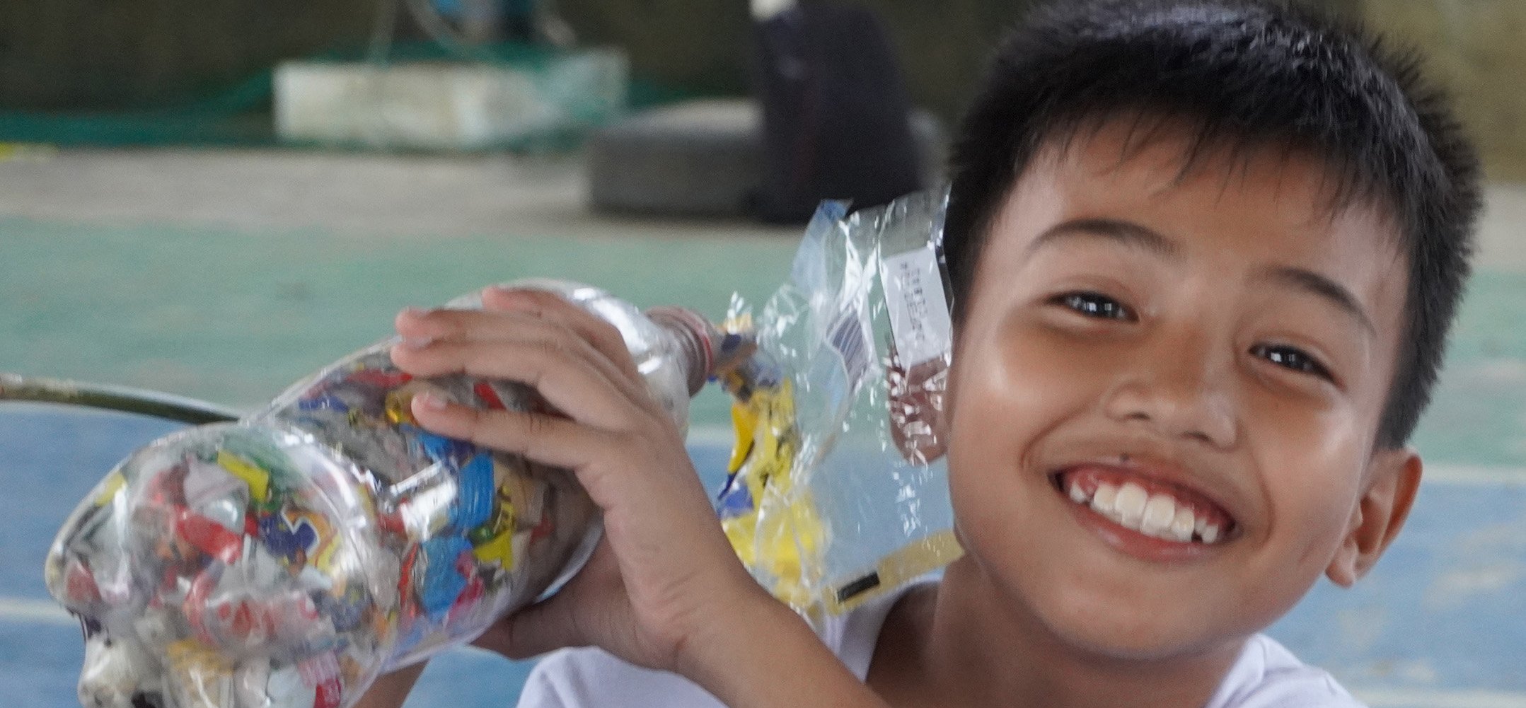 kid smiling with ecobrick_cropped.jpg