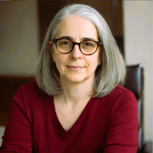 A photo of Kate, an older Yoga Teacher with grey hair and smiling eyes