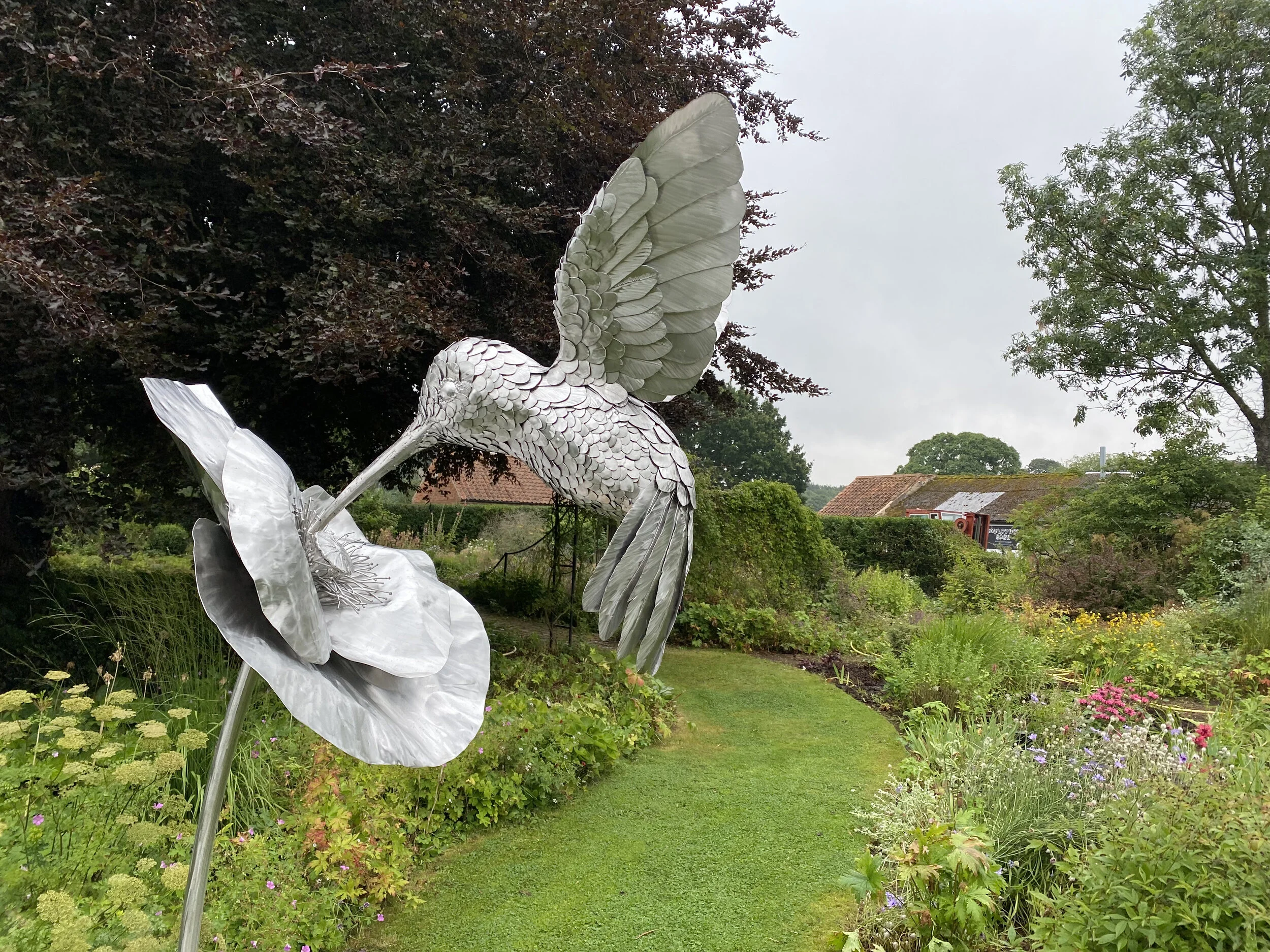  This stunning 9ft-tall hummingbird sculpture, commissioned by a private collector to mark a special wedding anniversary, is crafted from 316 stainless steel. Suspended from a flower by its beak, the hummingbird appears to float gracefully in space, 