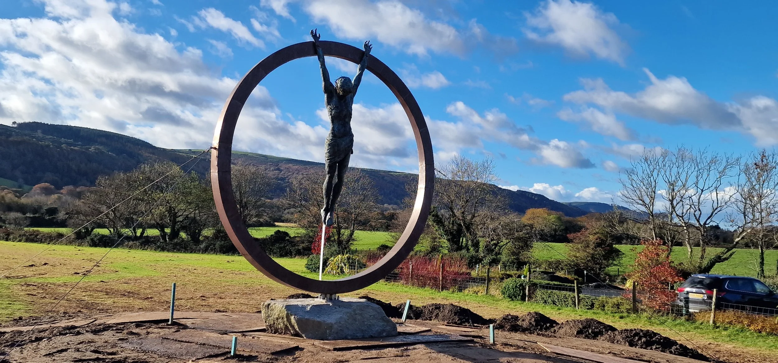   Sacrifice  is a monumental public art installation commissioned for a business on the Isle of Man. Standing at 3 meters tall, the sculpture features a life-sized bronze Christ figure suspended within a frame crafted from stainless steel and copper.