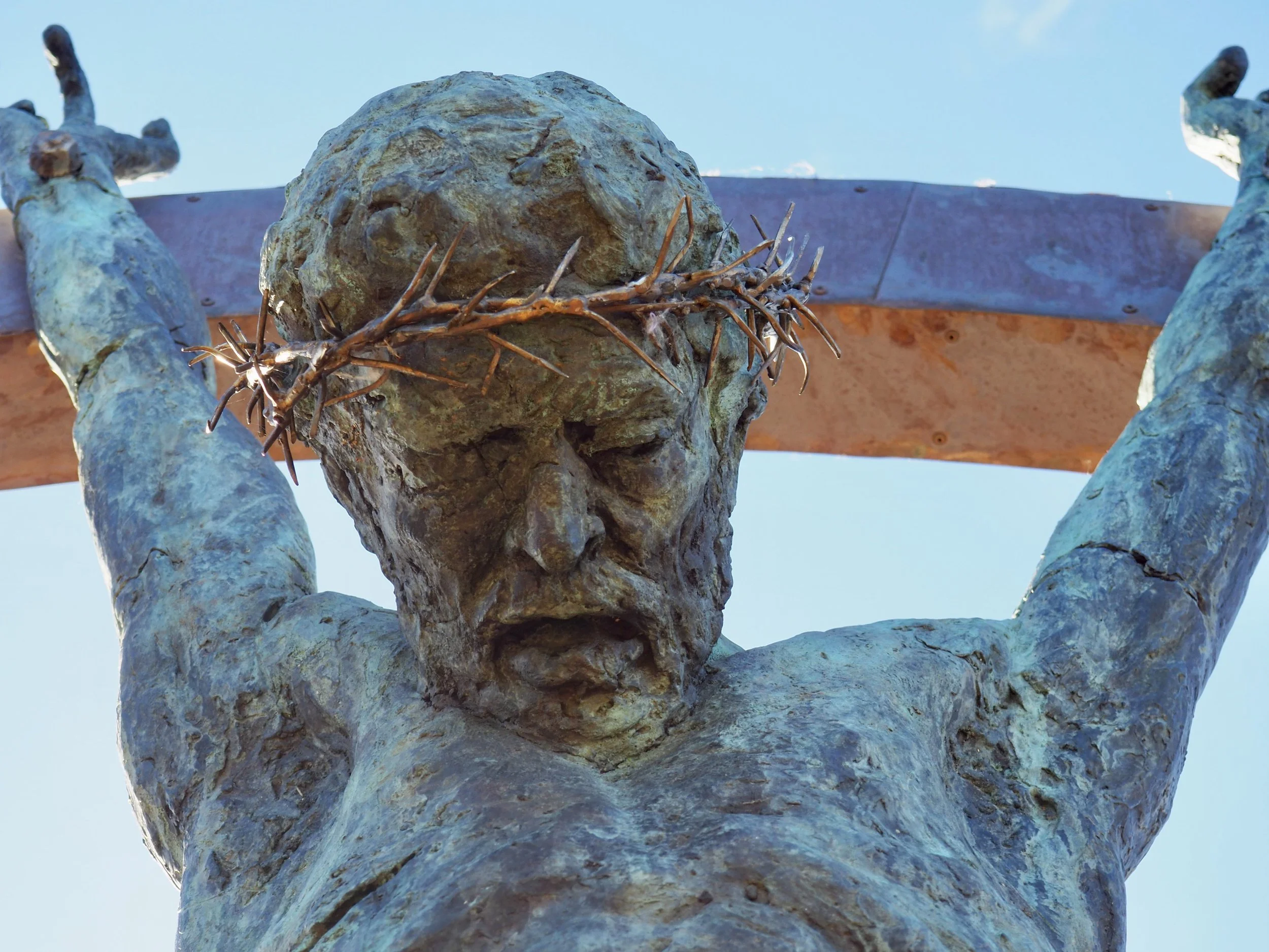   Sacrifice  is a monumental public art installation commissioned for a business on the Isle of Man. Standing at 3 meters tall, the sculpture features a life-sized bronze Christ figure suspended within a frame crafted from stainless steel and copper.