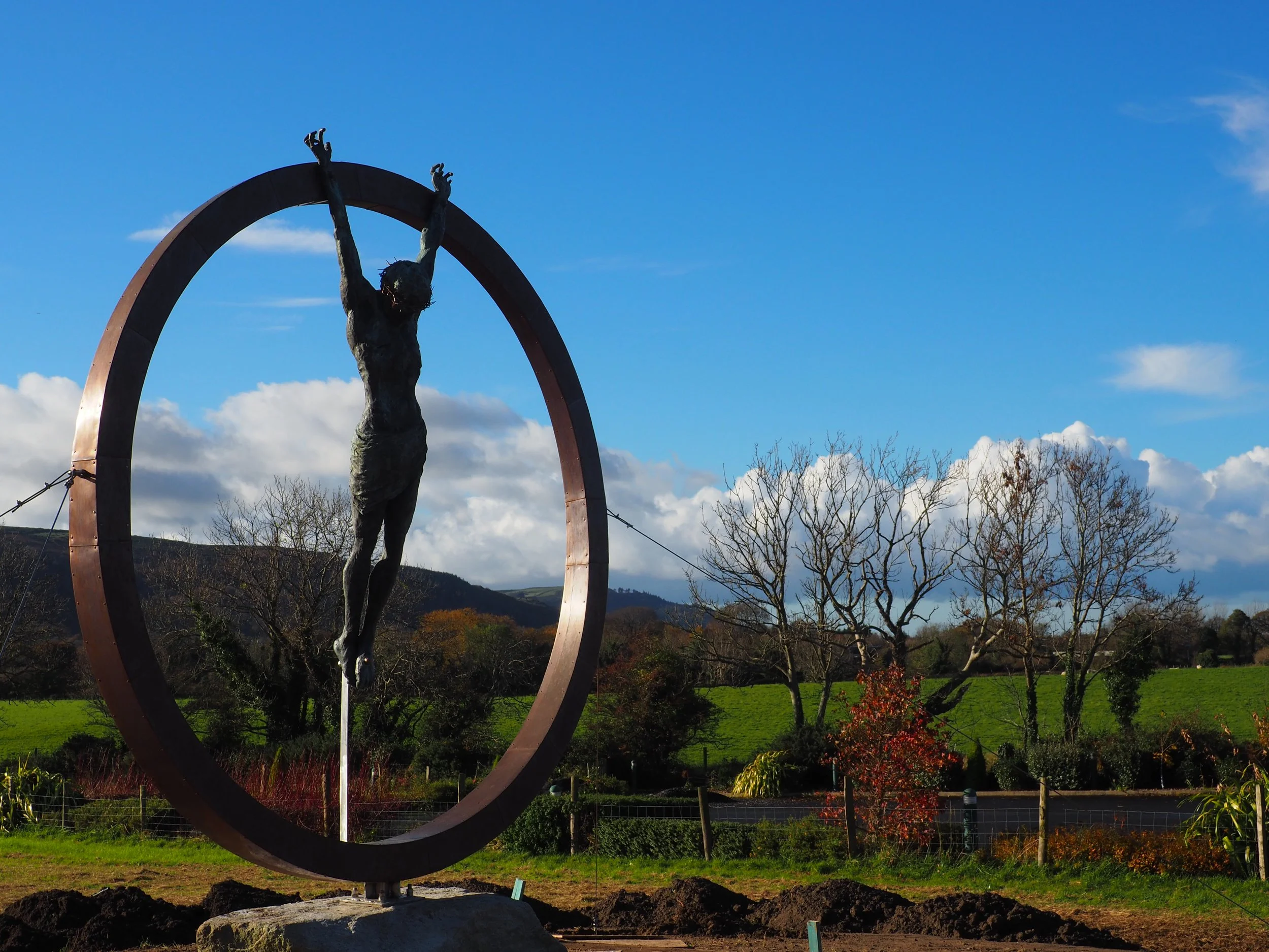   Sacrifice  is a monumental public art installation commissioned for a business on the Isle of Man. Standing at 3 meters tall, the sculpture features a life-sized bronze Christ figure suspended within a frame crafted from stainless steel and copper.