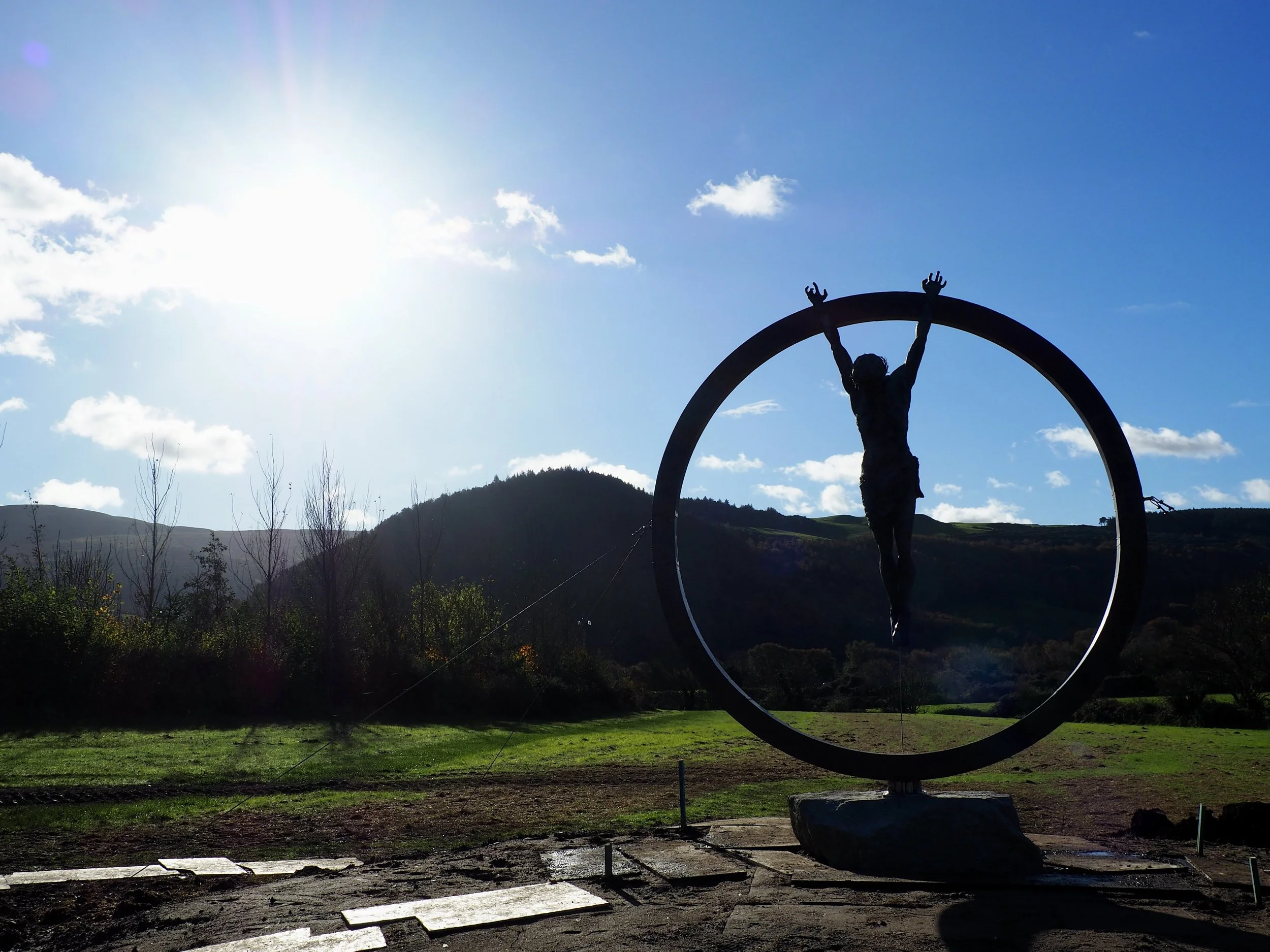   Sacrifice  is a monumental public art installation commissioned for a business on the Isle of Man. Standing at 3 meters tall, the sculpture features a life-sized bronze Christ figure suspended within a frame crafted from stainless steel and copper.