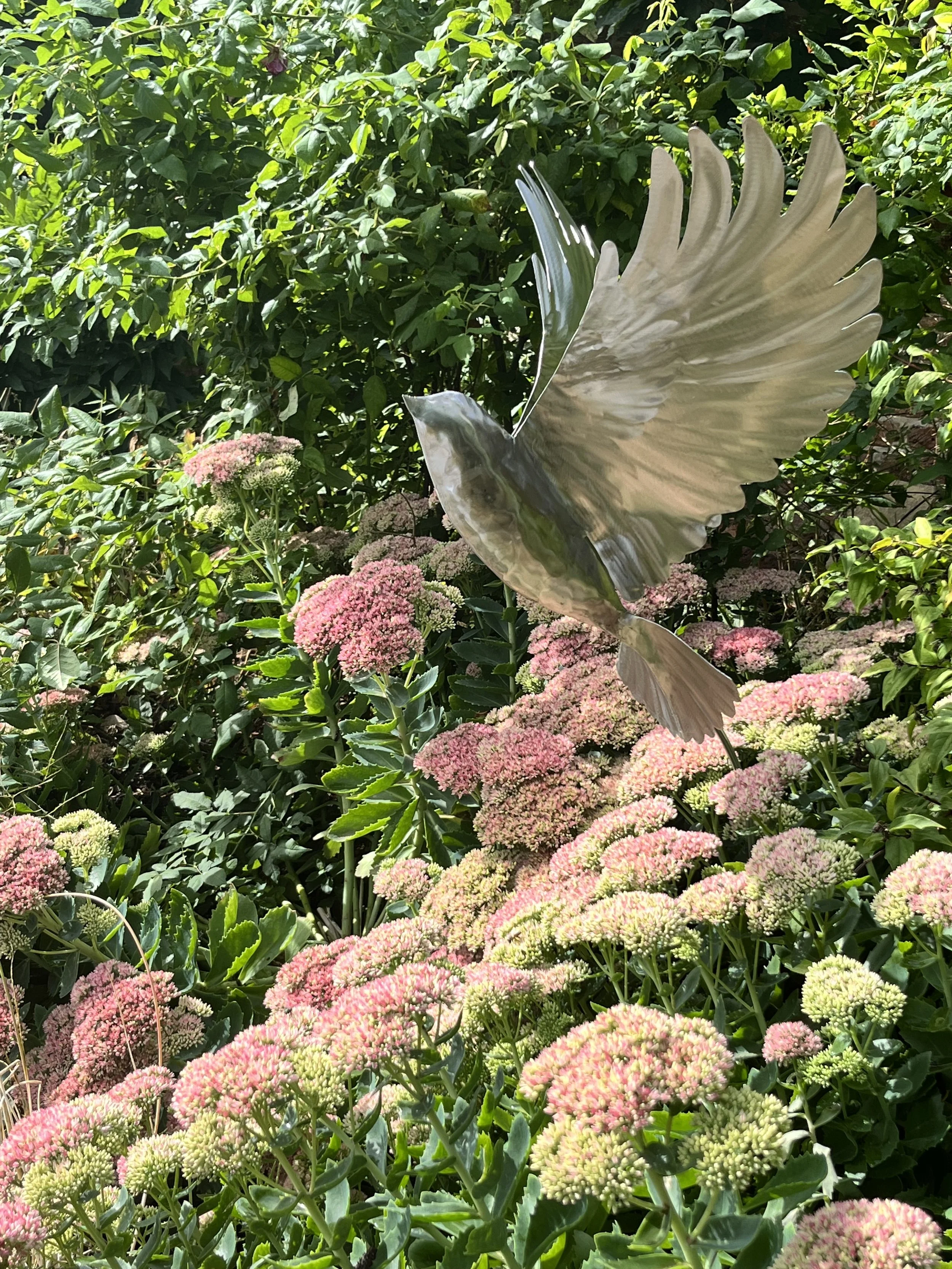Reflective Bird Sculpture in Landscaped Garden