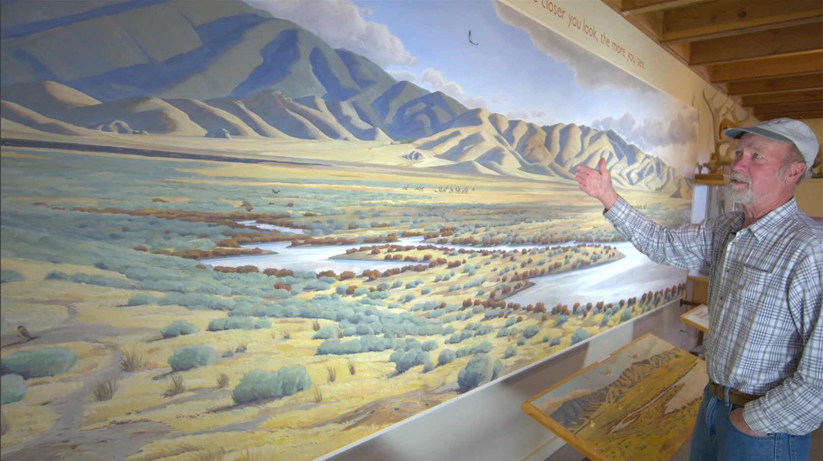 John Iwerks stands with a dramatic interpretive mural he produced in the early 1990s. Located at the Carrizo Plain National Monument Visitor Center, the mural was a just a portion of his three-year effort that included interactive and interpretive d…