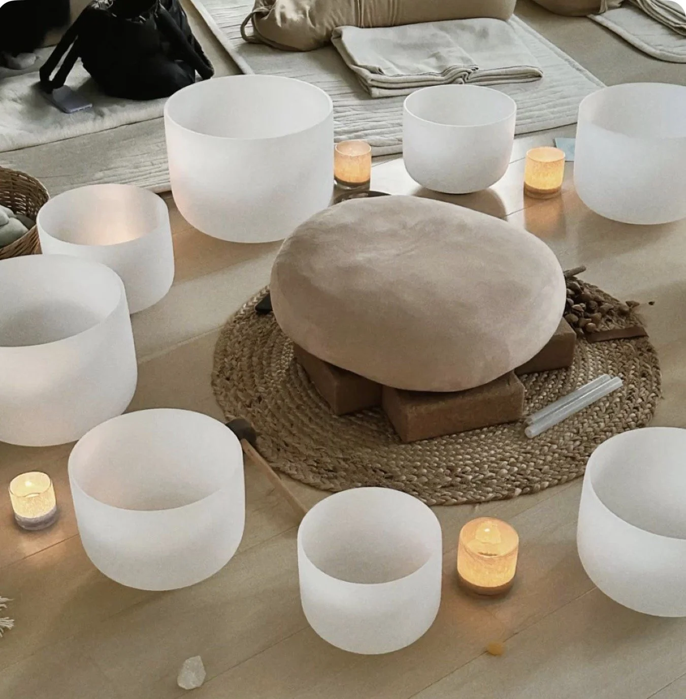 crystal sound bowls in a semi circle on the floor with candles around