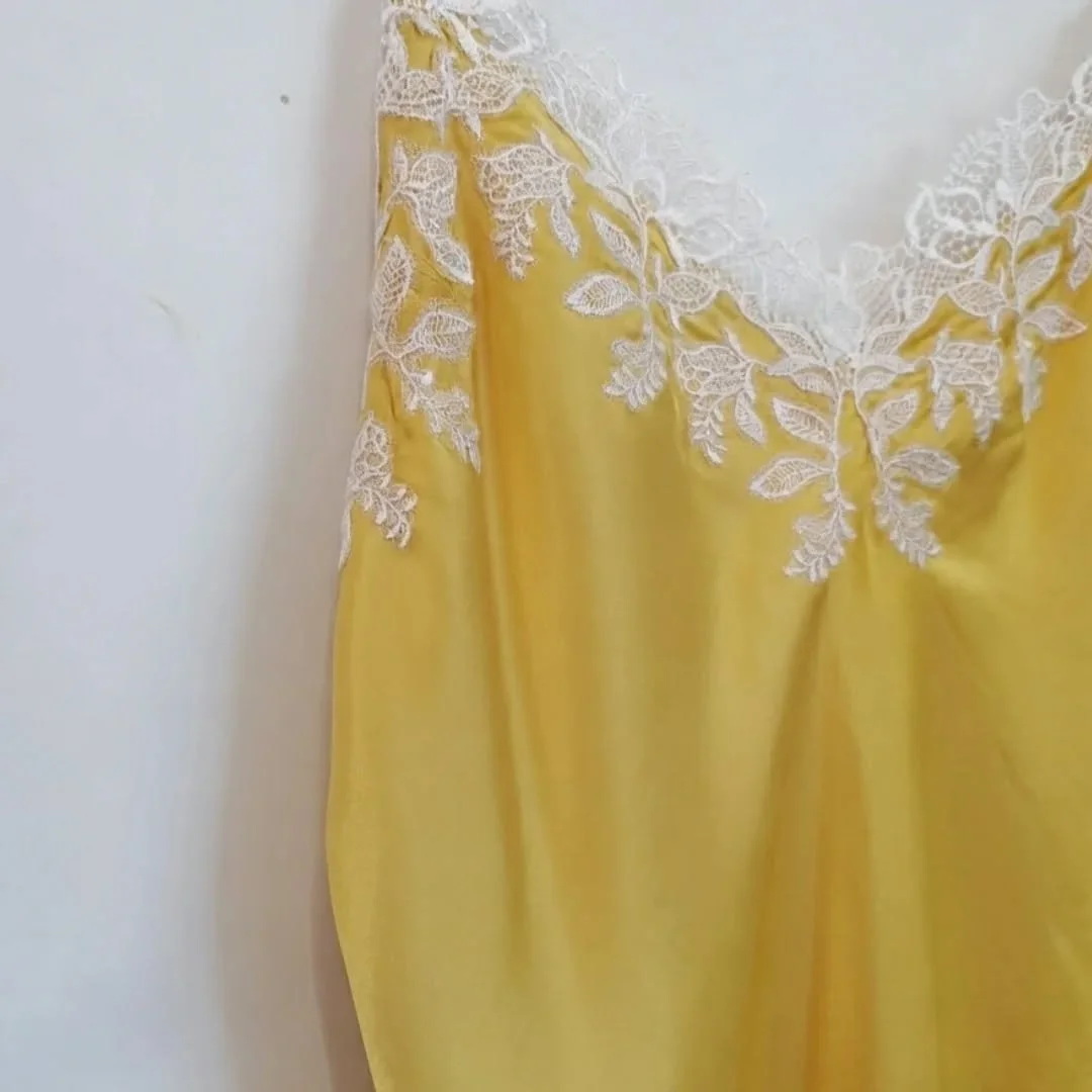 This buttery yellow slip dress is pure elegance &mdash; lightweight silk that drapes like a dream, finished with delicate white floral lace across the neckline. Perfect for layering or wearing solo on warm evenings.
The kind of piece that makes you f