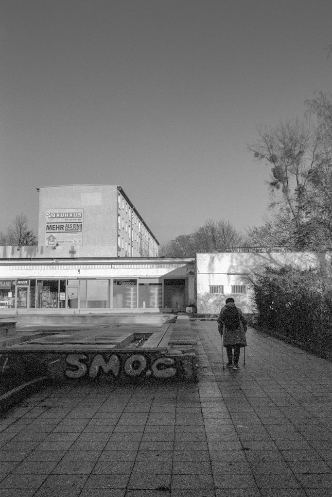 2023-01-05_Frau_Krücken_Bauhaus_Pentax_ME_super_JCH_Streetpan_400@200_web.jpg