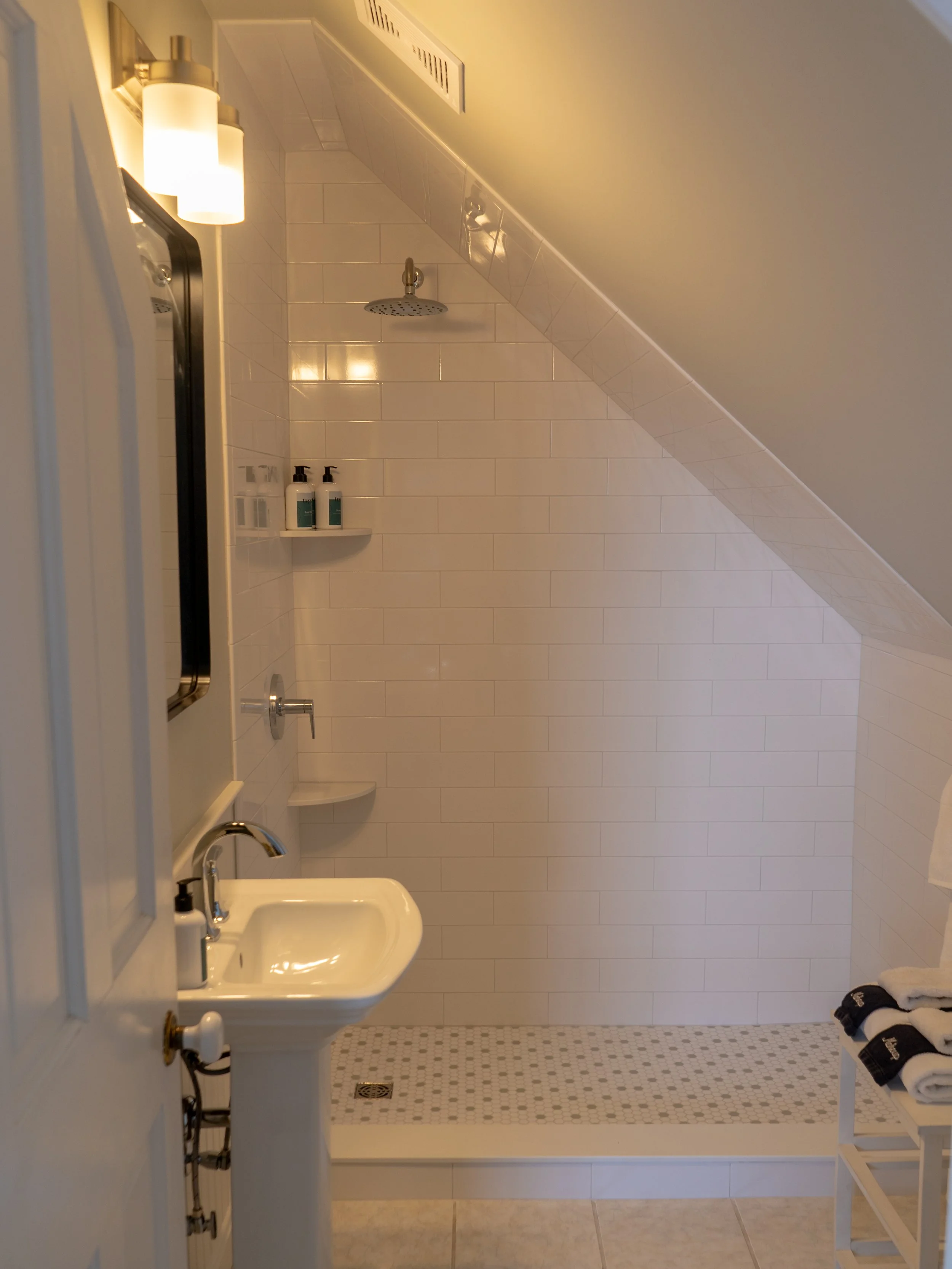 Bathroom in Room 5 at The Sailmaker’s House with sloped ceiling, pedestal sink, and tiled shower