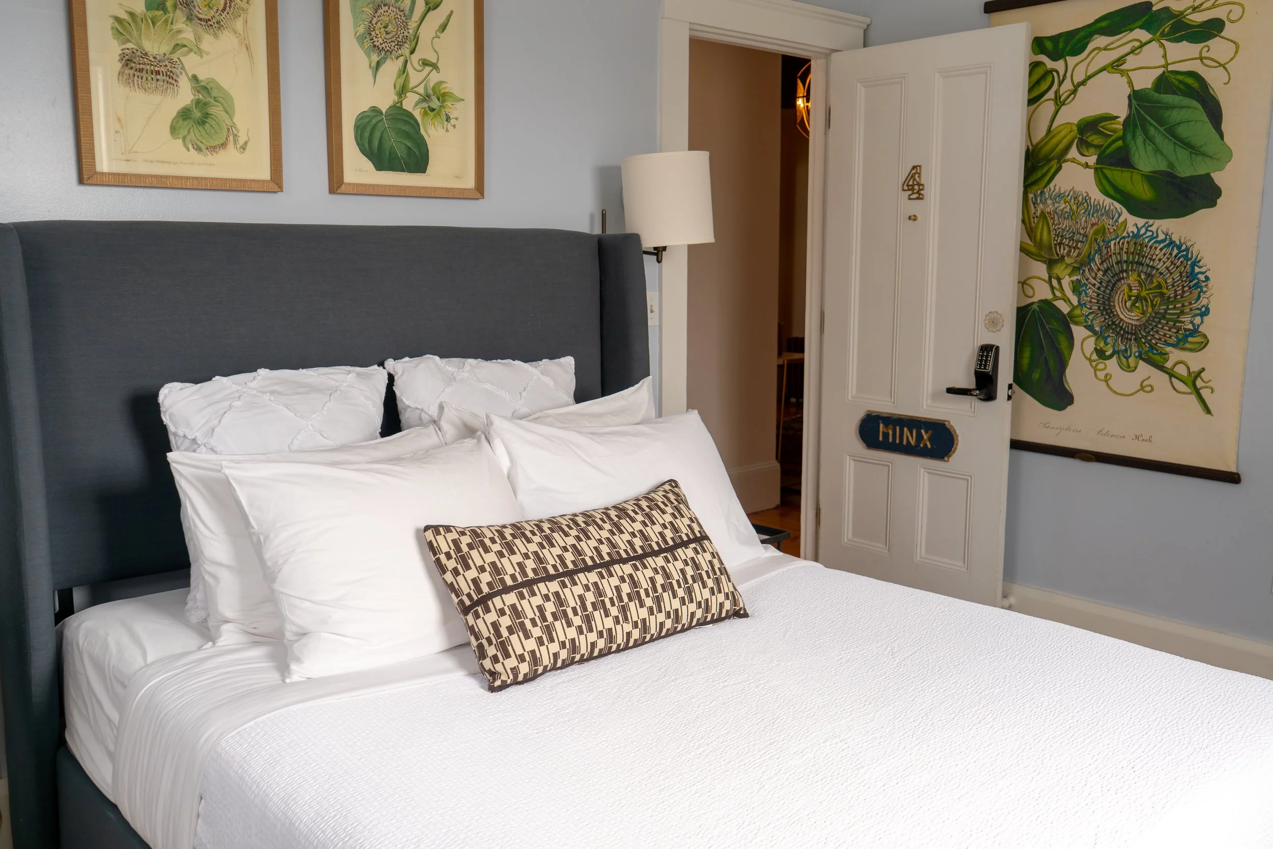 Bedroom in Room 4 at Water Street Inn with queen bed, botanical artwork, and natural light
