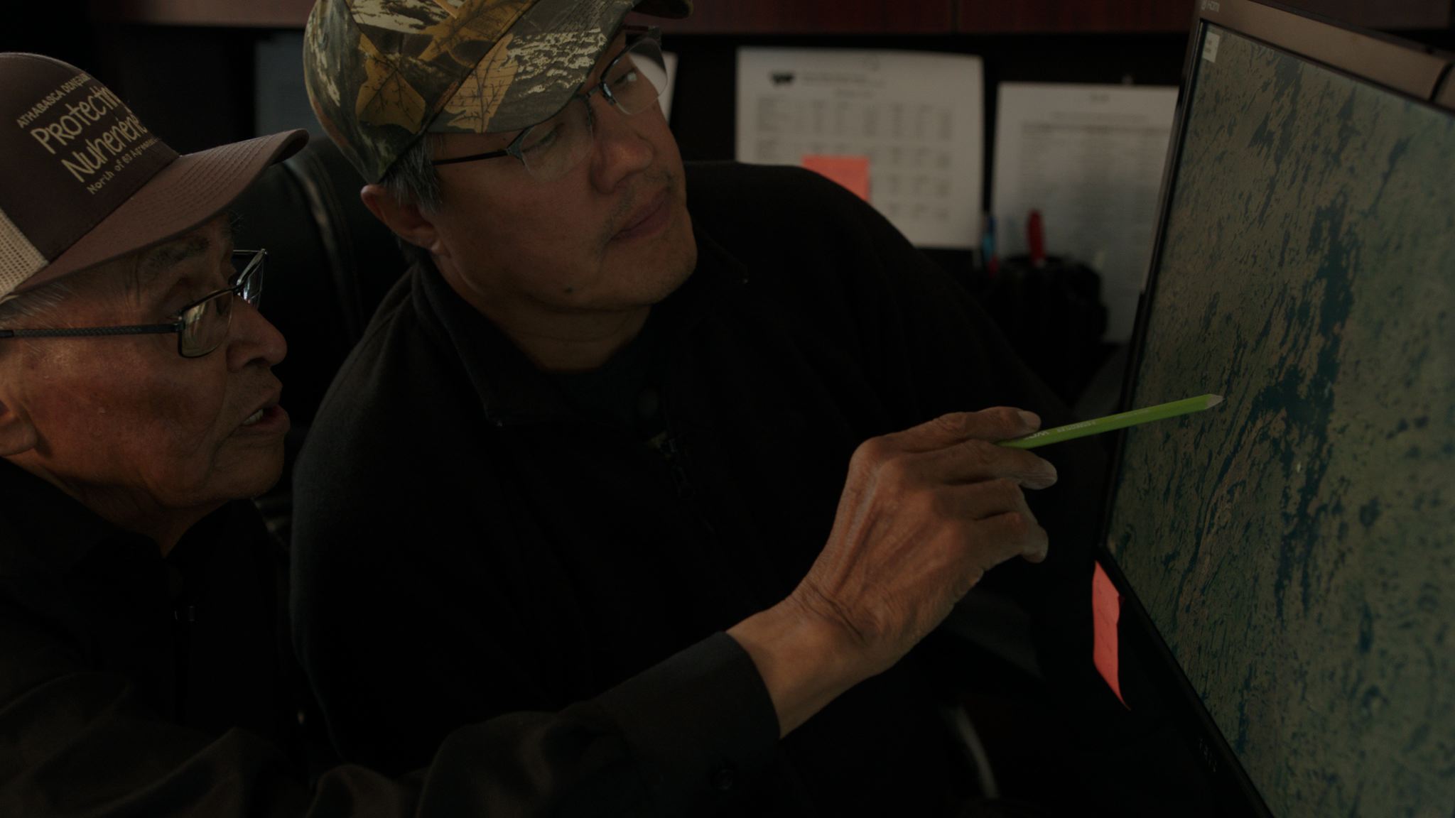  Ron Robillard (chief negotiator for the Athabasca Denesuline) and an elder map out traditional Déné territory. 