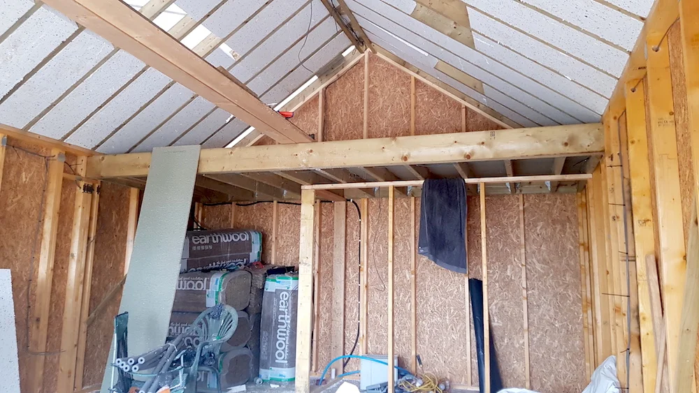 The roof insulation goes in, the mezzanine is up, and the structure for the shower room and kitchenette are coming together.