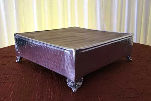 Stainless Steel Cake Stand with Rustic Wood Surface 13 1/2" x 13 1/2" x 5 1/4" tall $20.00 17 1/2" x 17 1/2" x 6 1/4" tall $25.00 21 1/2" x 21 1/2" x 6 1/4" tall $35.00
