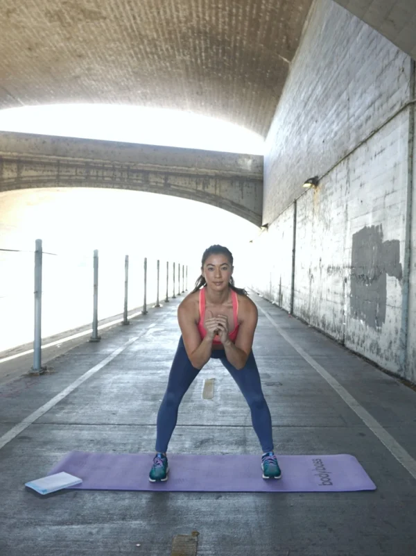 With your feet slightly wider than shoulder distance apart, do a squat without letting your knees go beyond your toes. Try to lower yourself back until your thighs are parallel to the ground