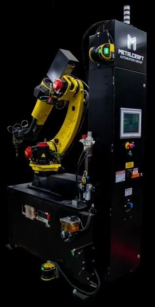 A large, yellow robotic arm used for CNC machining. It is attached to a black base machine with controls on it.