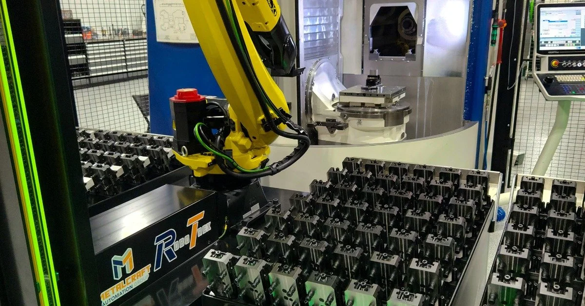 A yellow mechanical RoboTrex arm and the cartridges posed next to it. "Metalcraft Automation Group" is written on the side.