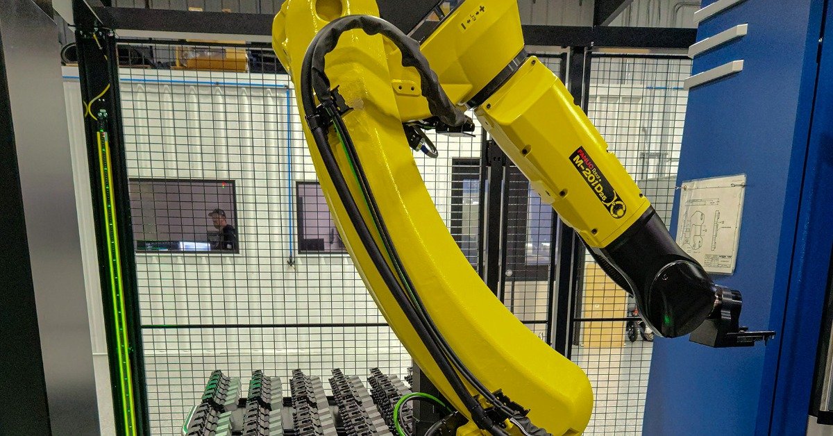 A closeup on the black cartridges next to a yellow robotic arm. The arm is folded up and ready to be used.