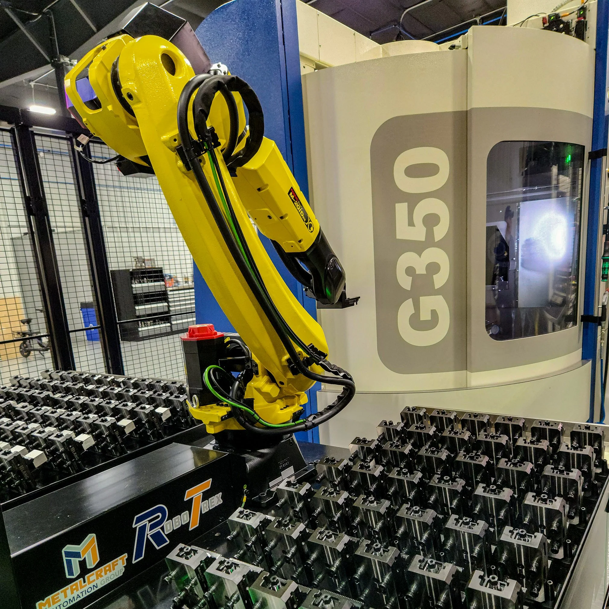 A closeup on a yellow, robotic arm with multiple bundles of black wires coming out of the side of it.