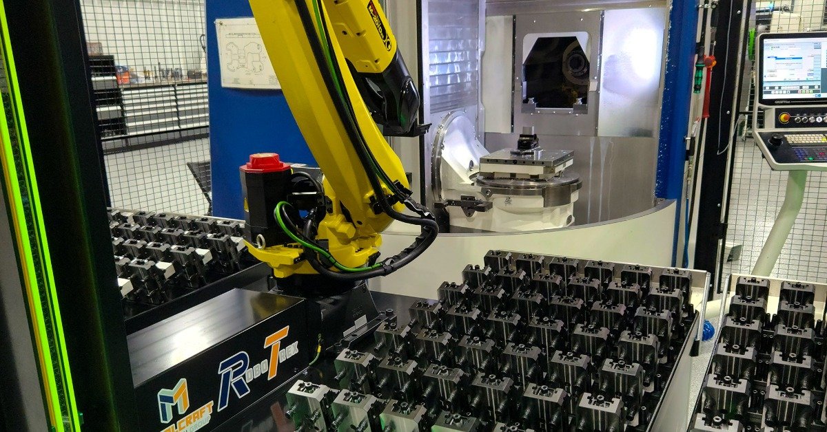 A view from outside of a RoboTrex CNC machine robot arm. There are multiple cartridges next to the robot arm.