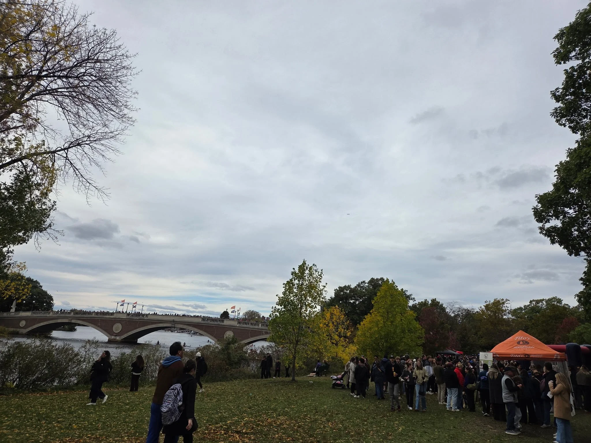 The festival atmosphere along the Charles River, with visitors exploring tents and activities near the racecourse. Photo: GoBoston.