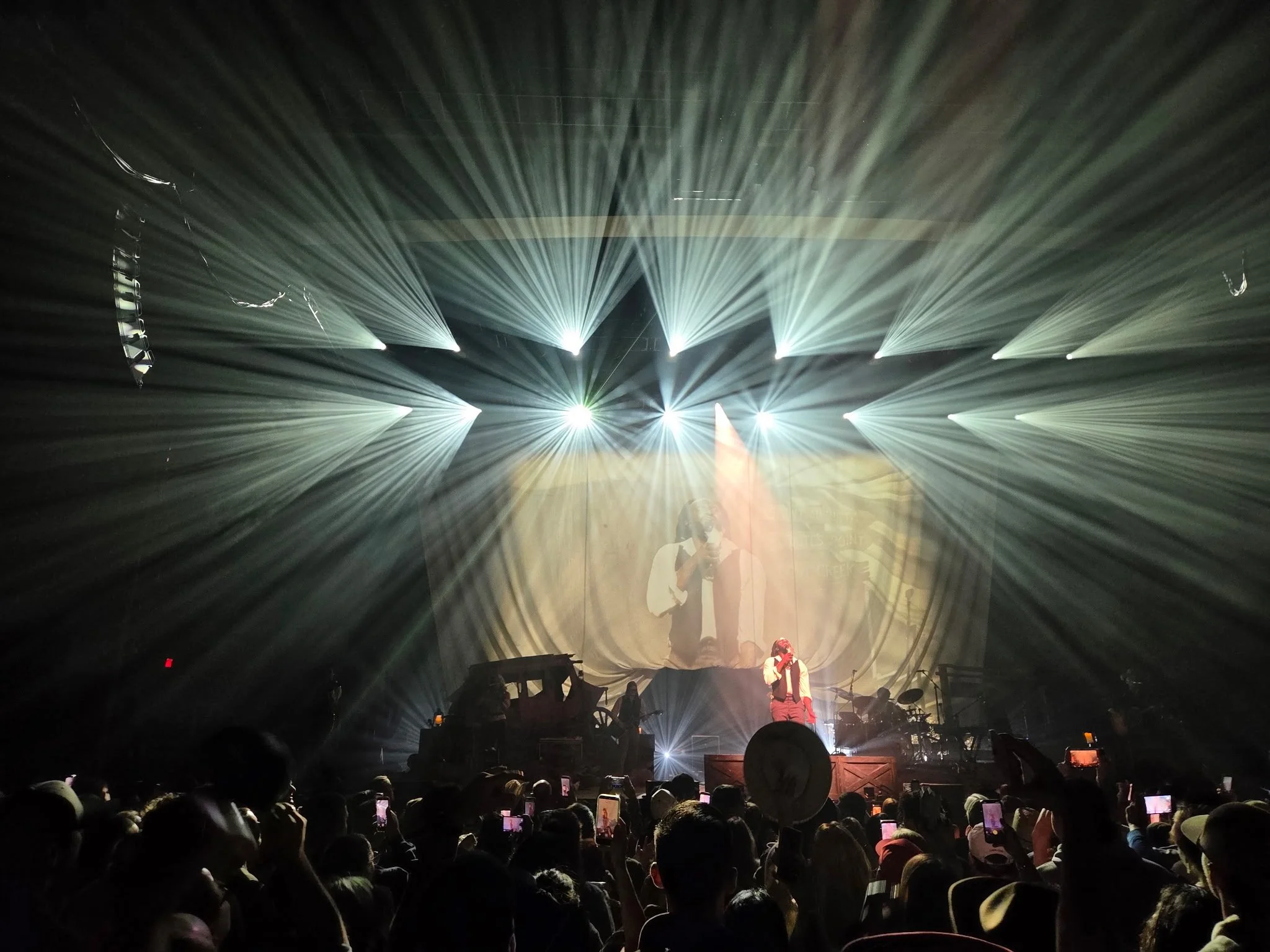 Dramatic white stage lights radiating over Shaboozey and the audience at MGM Music Hall at Fenway in Boston.