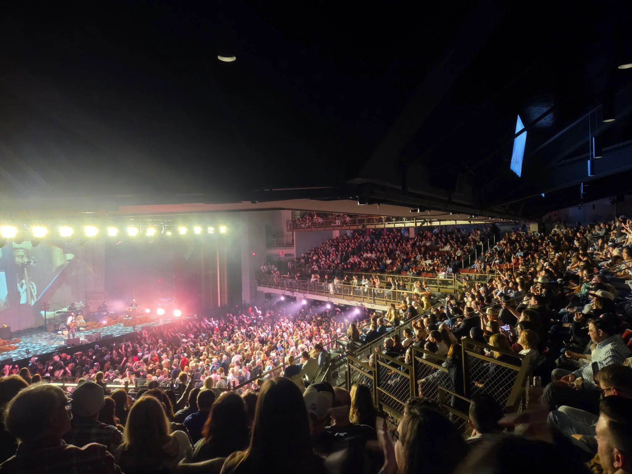 View from an upper level of MGM Music Hall at Fenway showing the packed floor and balconies wrapping around the concert hall.