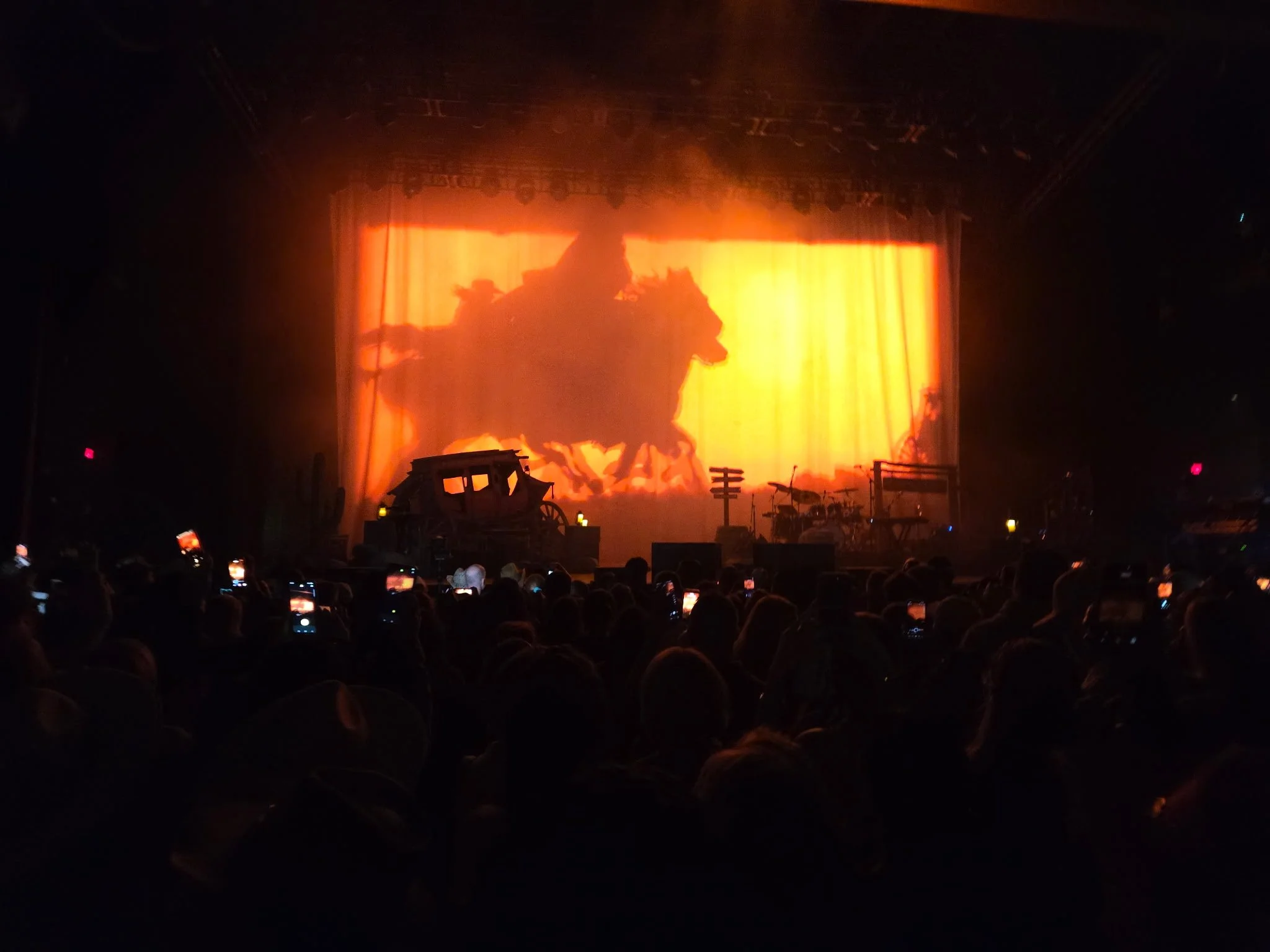 A horse and rider silhouetted against an orange Western backdrop during Shaboozey's concert at MGM Music Hall at Fenway.