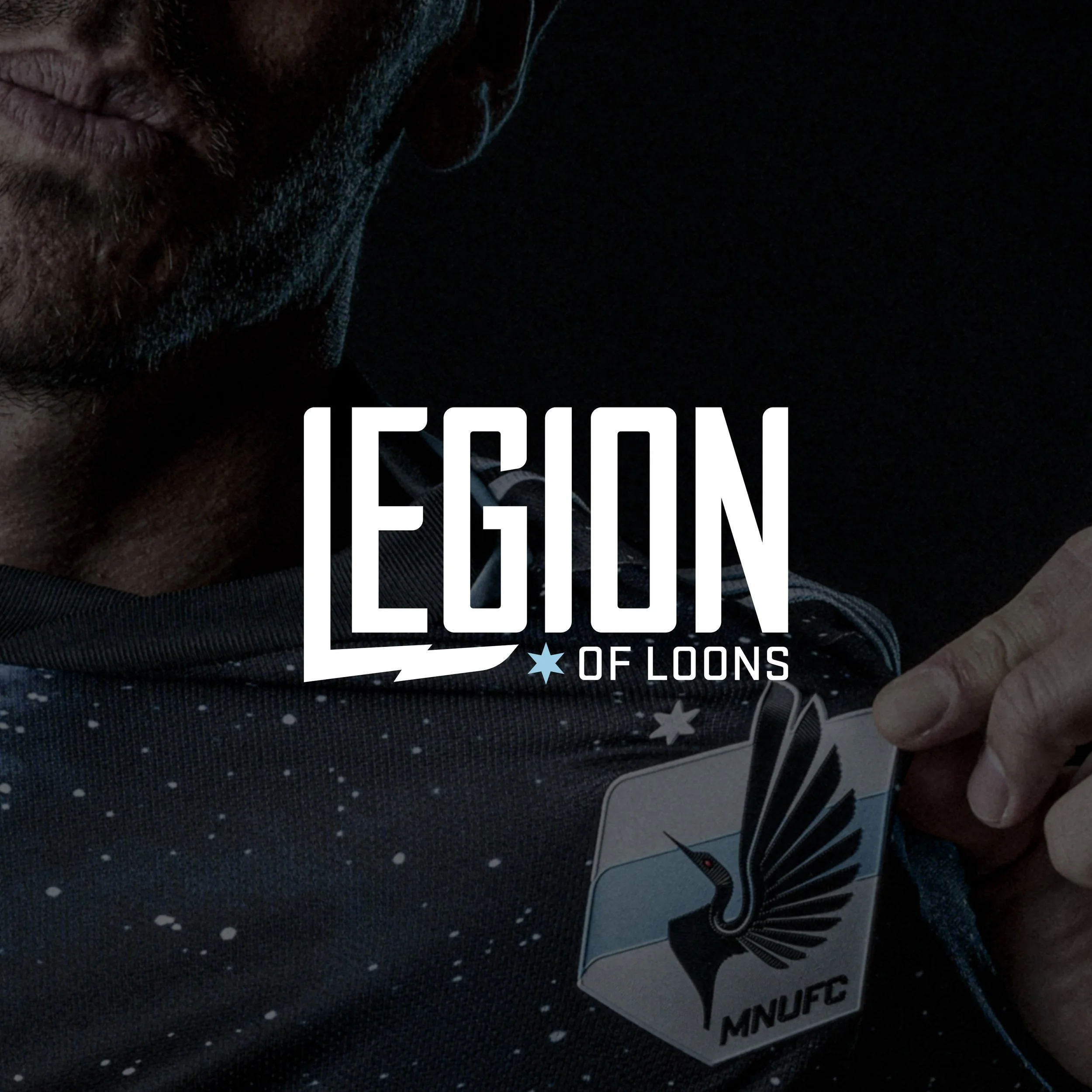Close-up of a partial face with a beard and lips, a sticker on a dark surface with stars and text that reads 'Legion of Loons'.