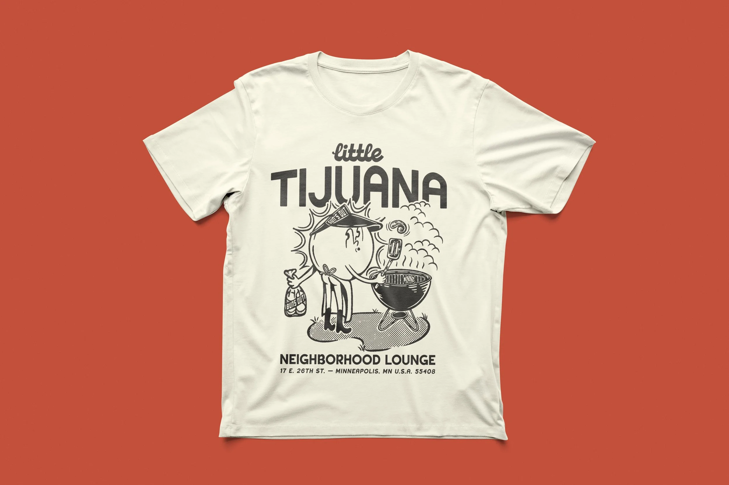 A white T-shirt with a black graphic design featuring a cartoon sun character wearing a visor, grilling a steak, with the text "Little Tijuana" and "Neighborhood Lounge" and the address at the bottom.