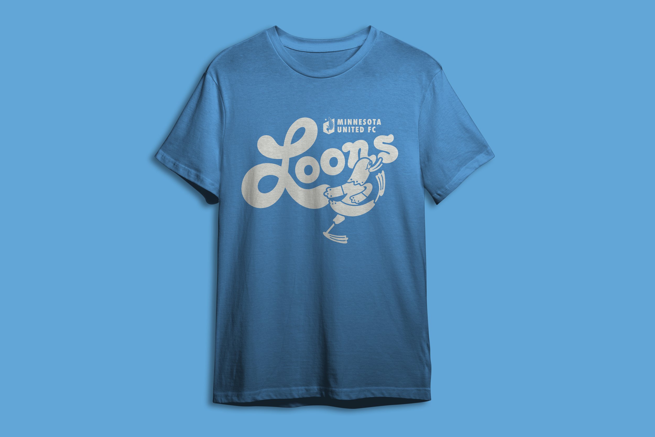 A blue T-shirt with a Minnesota United FC logo and graphic of a loon kicking.