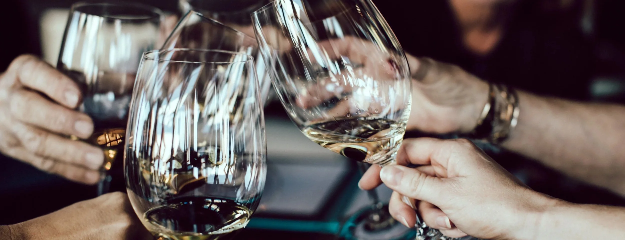 Group of people clinking wine glasses in a toast