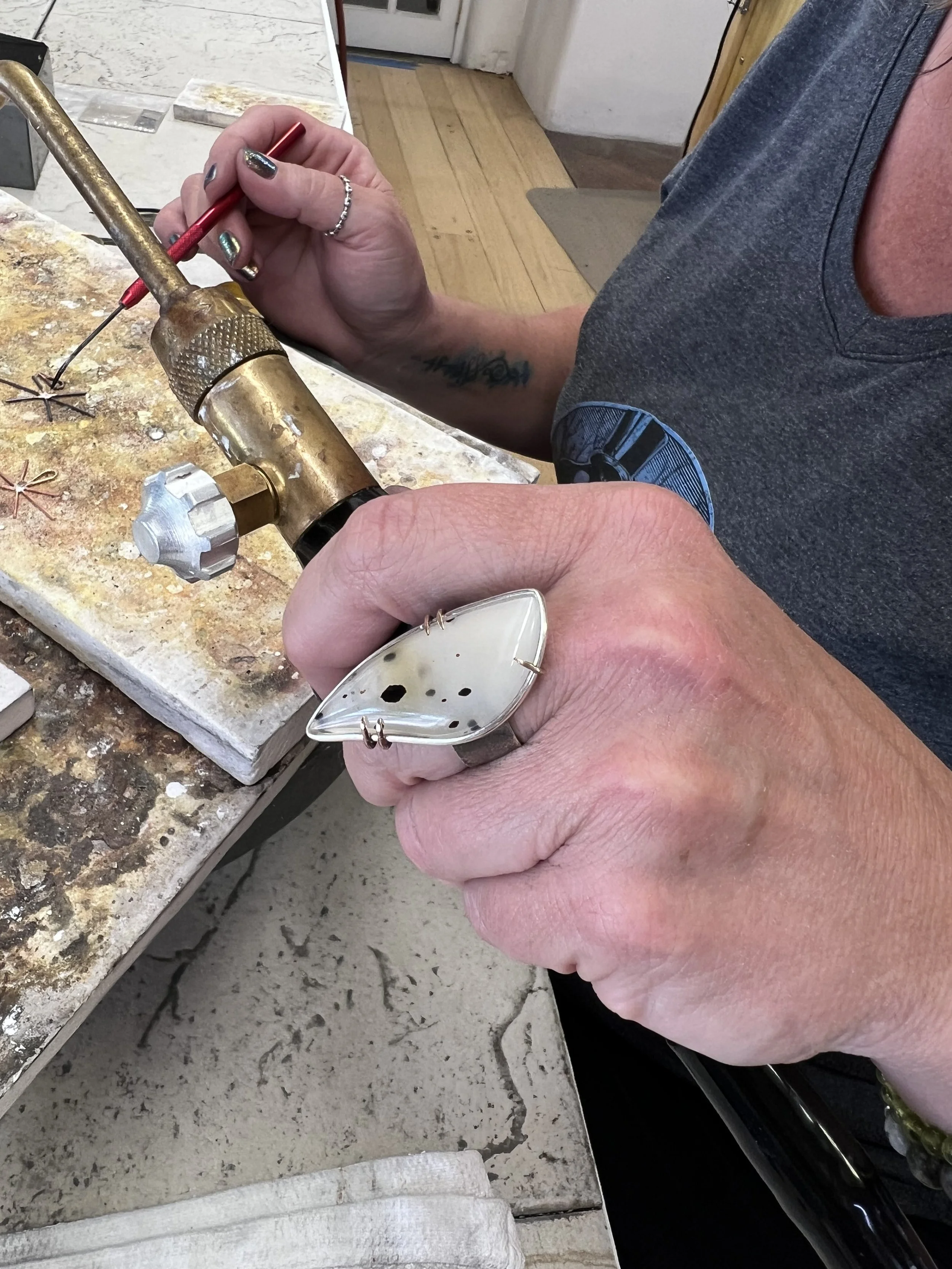 Torch soldering technique during a silversmithing class in Albuquerque workshop