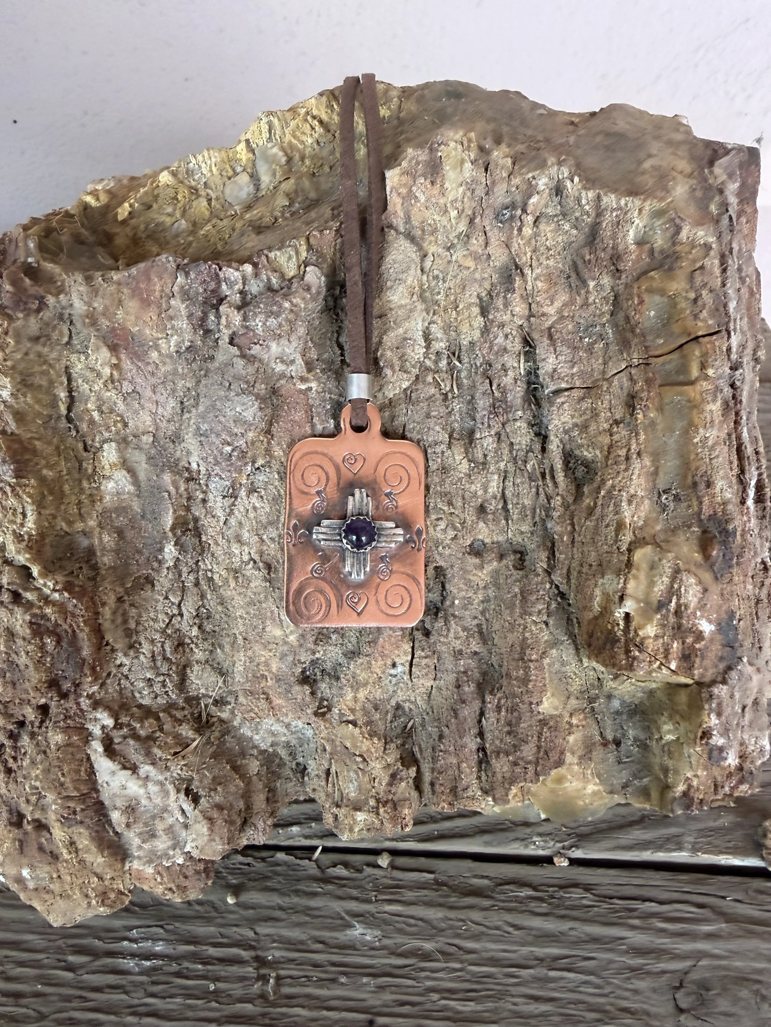 Finished stamped Zia necklace with turquoise displayed on stone, created in a jewelry making class in Albuquerque.